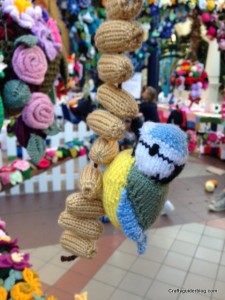 Knitted blue tit and peanuts pergola